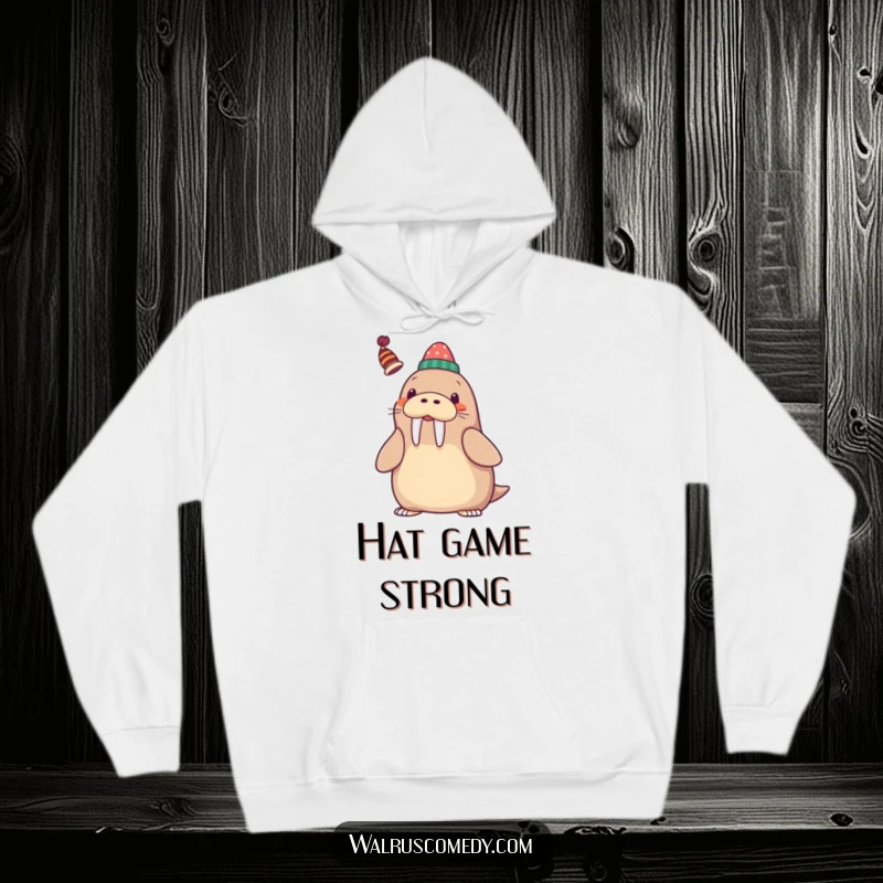 Funny Hoodie depicting a kawaii walrus playfully balancing a small, whimsical hat on its tusk, radiating joy.